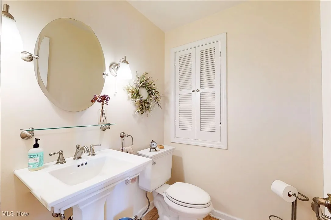 Half bath featuring toilet and baseboards