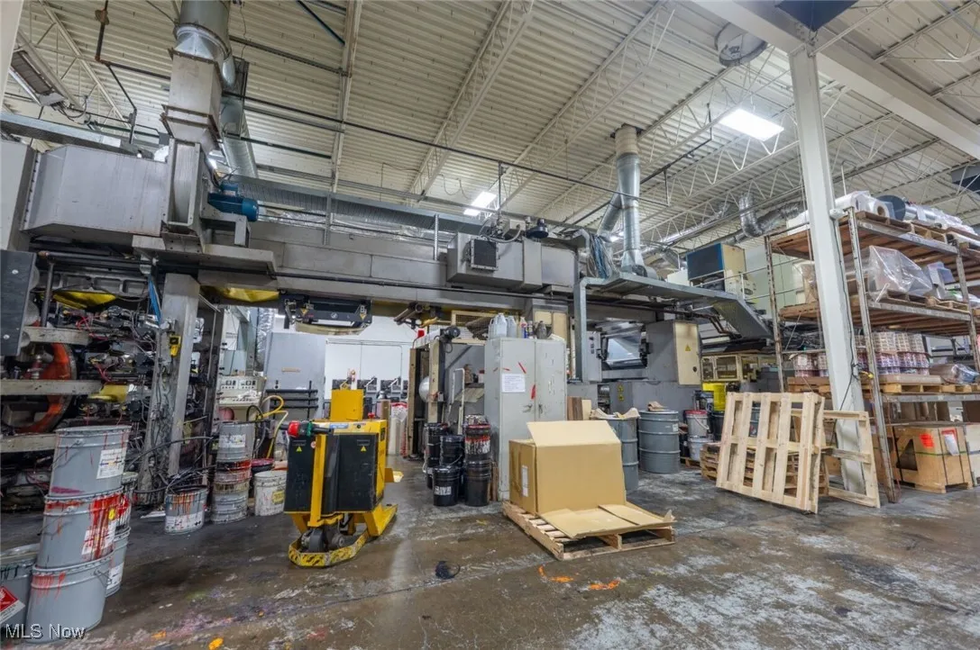 Garage with metal wall, a workshop area, and water heater