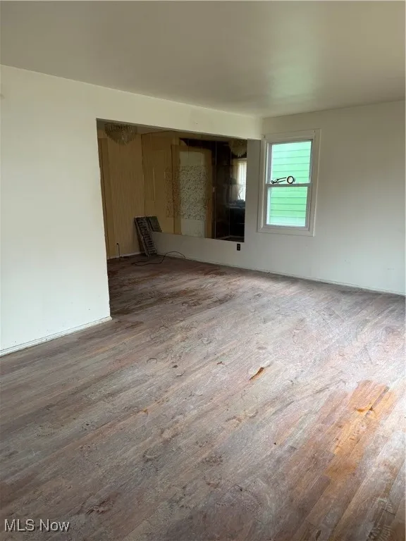 Unfurnished room featuring wood finished floors and baseboards
