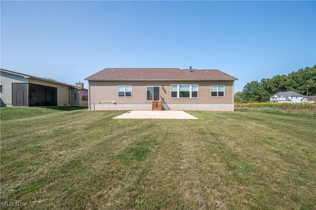 Back of property with a patio and a lawn