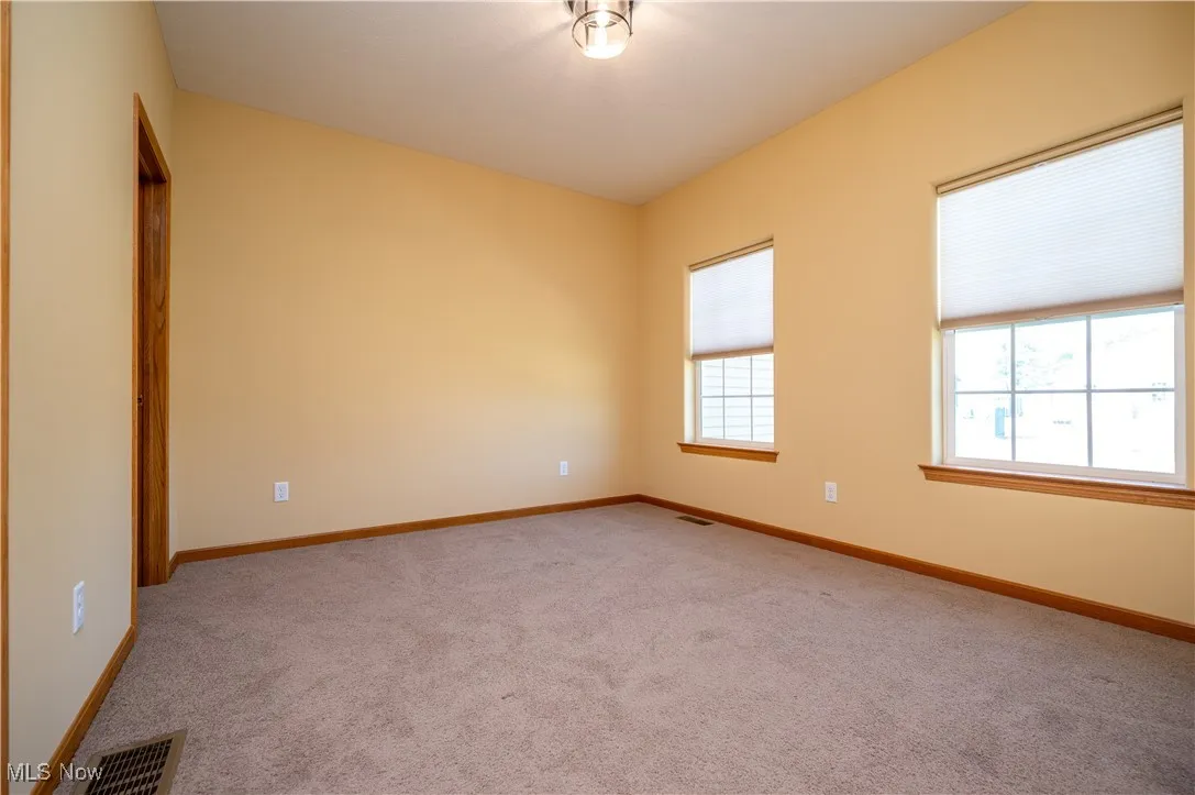 Spare room with carpet and baseboards