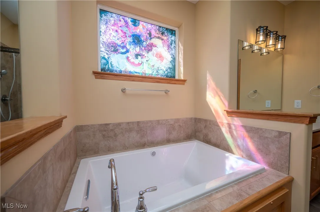 Full bathroom featuring a bath, an enclosed shower, and vanity