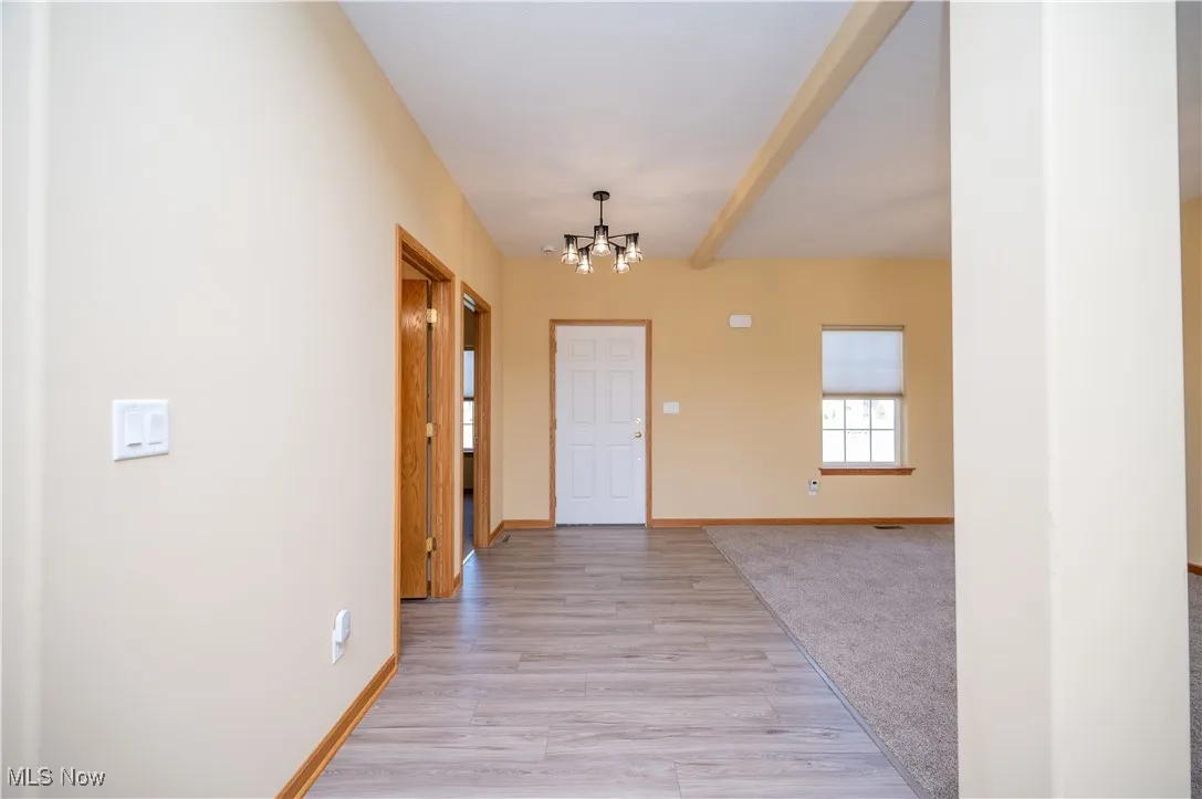 Entryway with a chandelier, light wood finished floors, and light colored carpet