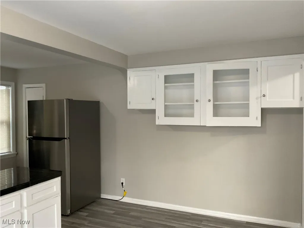Eat in Kitchen with white cabinetry, freestanding refrigerator
