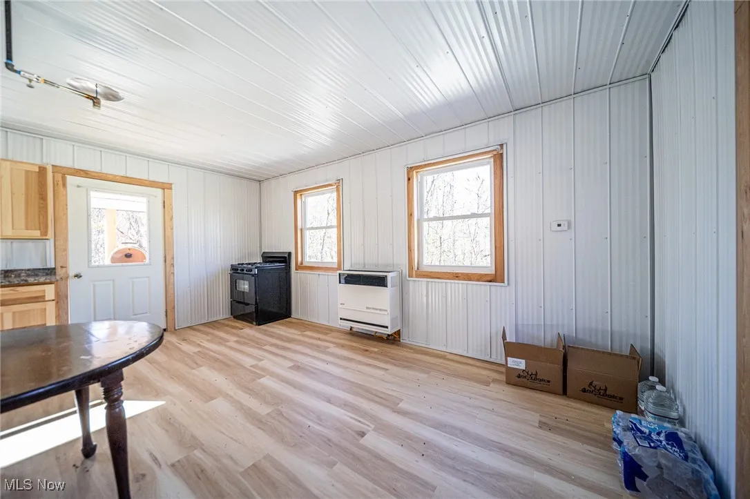 Office area with light wood-type flooring and heating unit