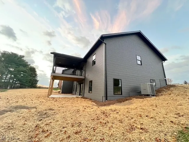 View of side of property featuring a patio and a deck