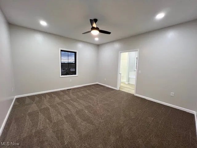 Unfurnished room featuring dark carpet, recessed lighting, and a ceiling fan