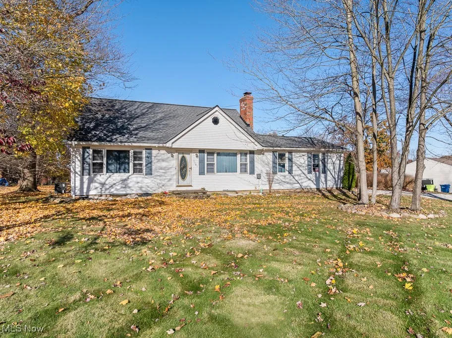 View of front of home with a chimney and a front lawn