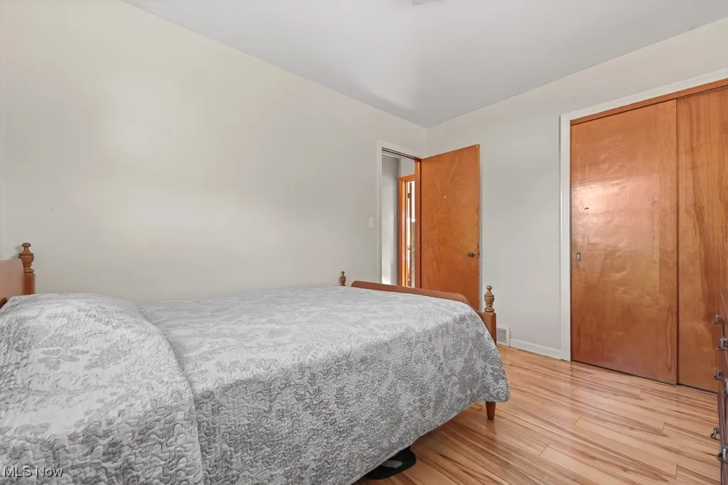 Bedroom with light wood-style floors and a closet