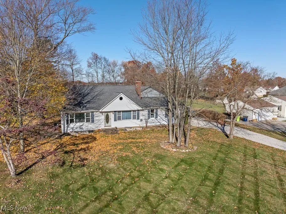 View of front of property with a chimney and a front lawn