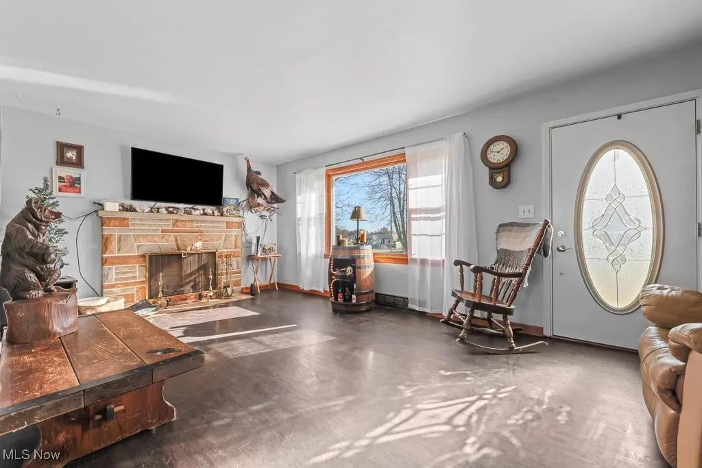 Living area featuring finished concrete flooring and a stone fireplace