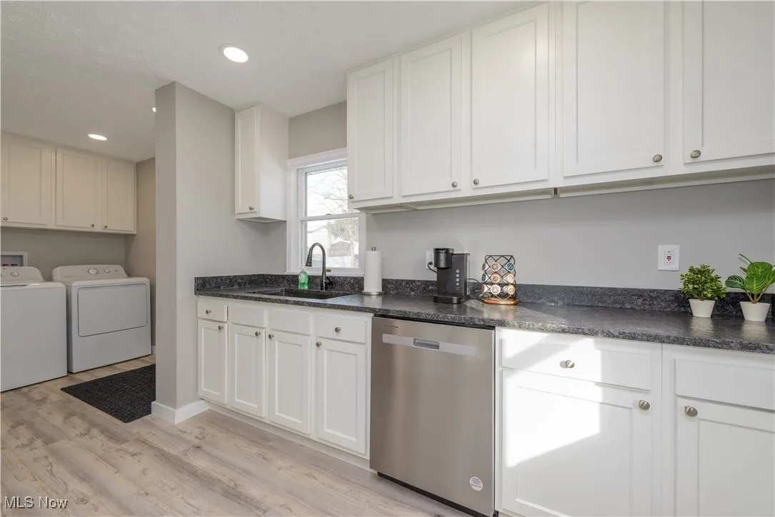 Kitchen featuring dishwasher, white cabinets, washer and dryer, light wood finished floors, and recessed lighting