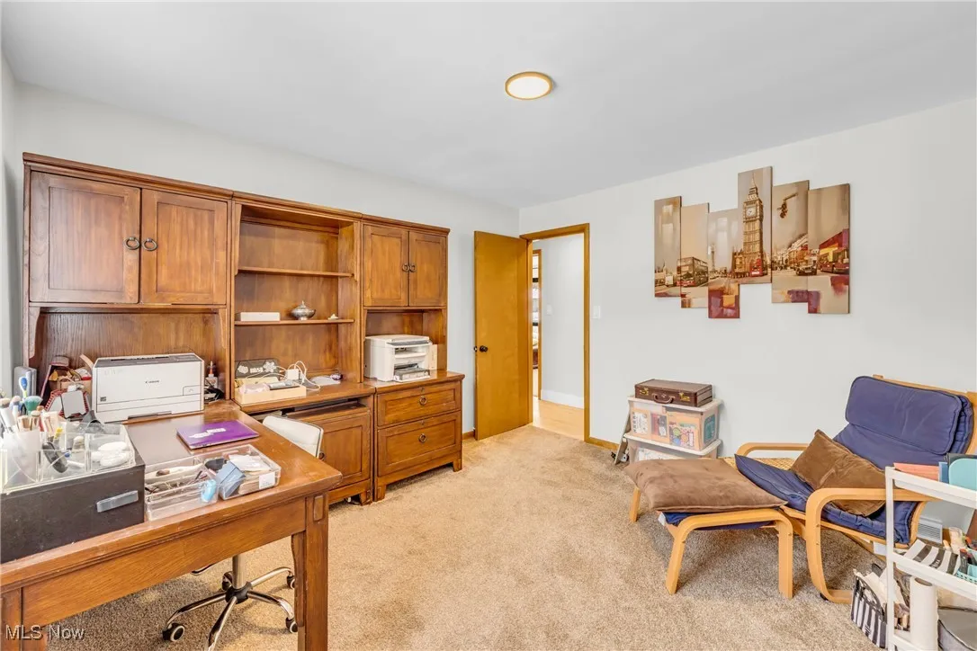 Home office featuring light carpet and baseboards
