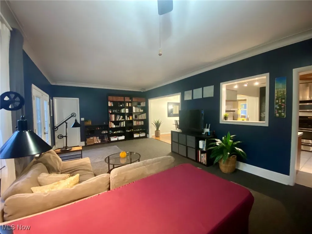 Living area with carpet flooring and crown molding
