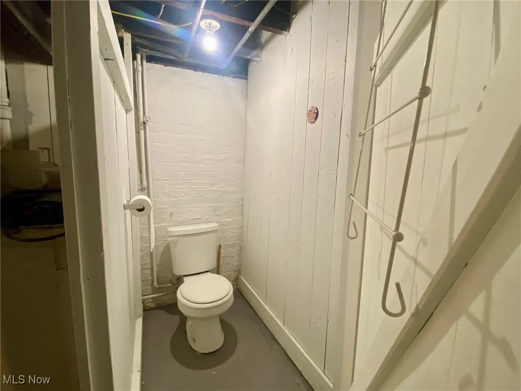 Bathroom featuring concrete flooring and wooden walls