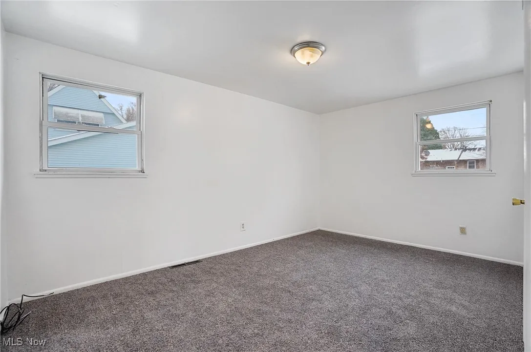 Carpeted spare room with baseboards