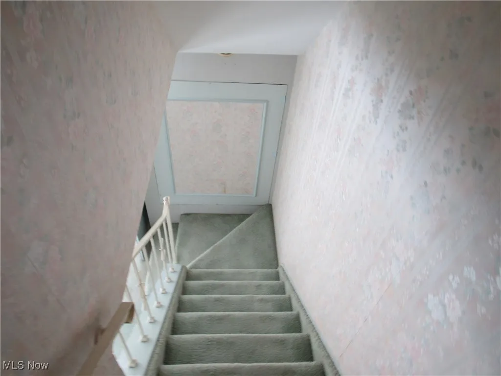 Stairs featuring wallpapered walls
