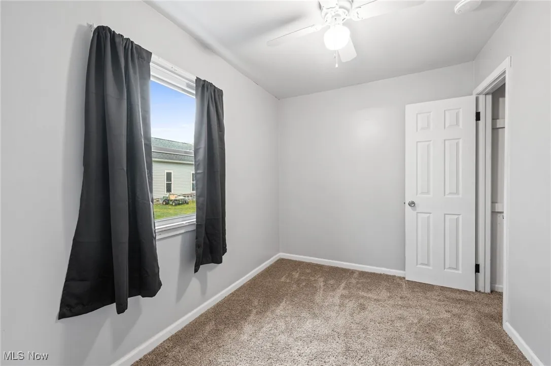 Unfurnished room featuring light carpet and ceiling fan