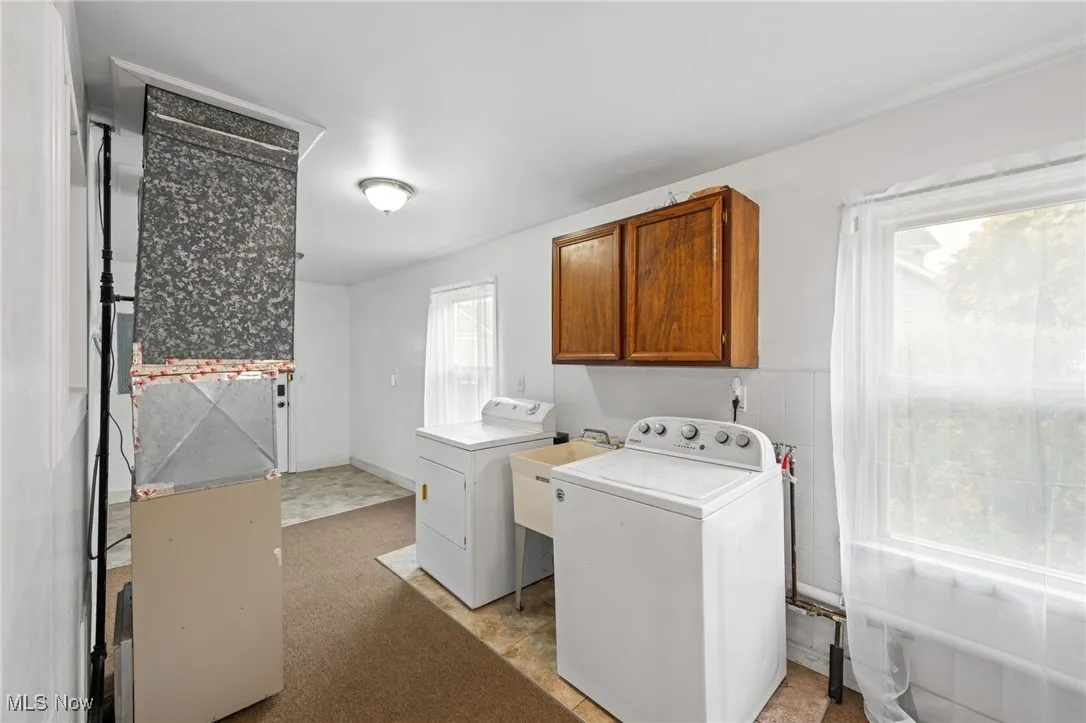Washroom with heating unit, cabinet space, and independent washer and dryer