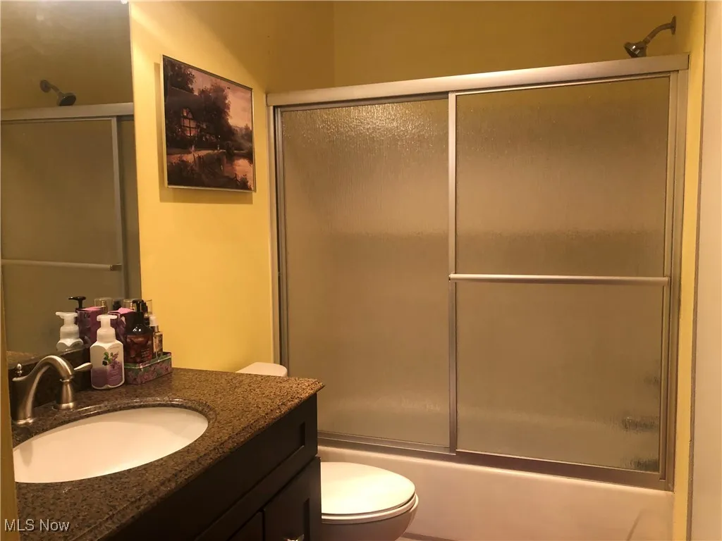 Full bathroom with vanity and combined bath / shower with glass door