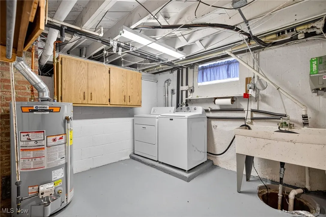 Basement with water heater and washing machine and clothes dryer