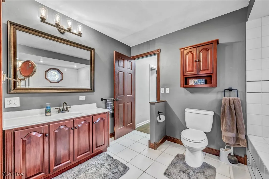 Full bathroom with light tile patterned floors and vanity