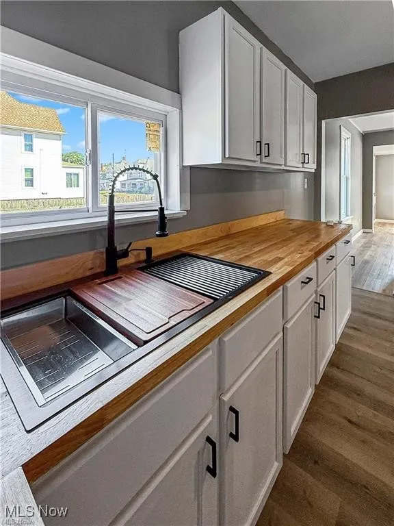 Kitchen featuring white cabinetry, wood counters, and dark wood finished floors