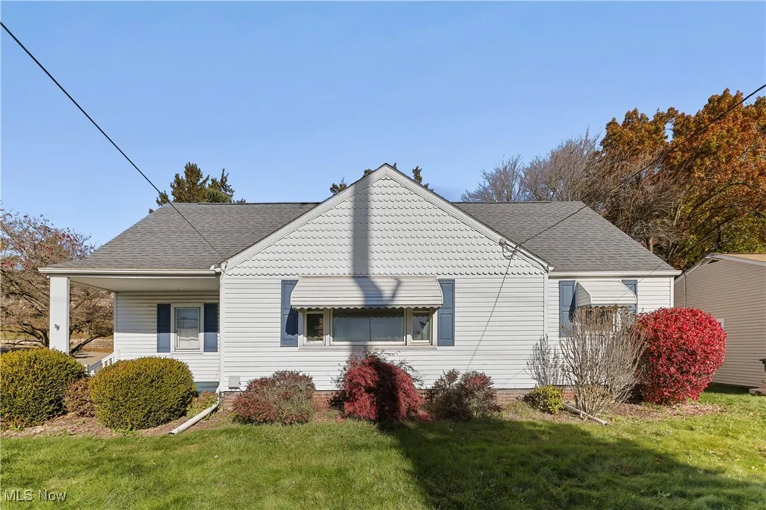 View of property exterior with a shingled roof and a yard