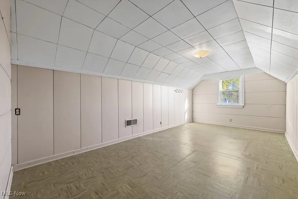Additional living space with vaulted ceiling and baseboards