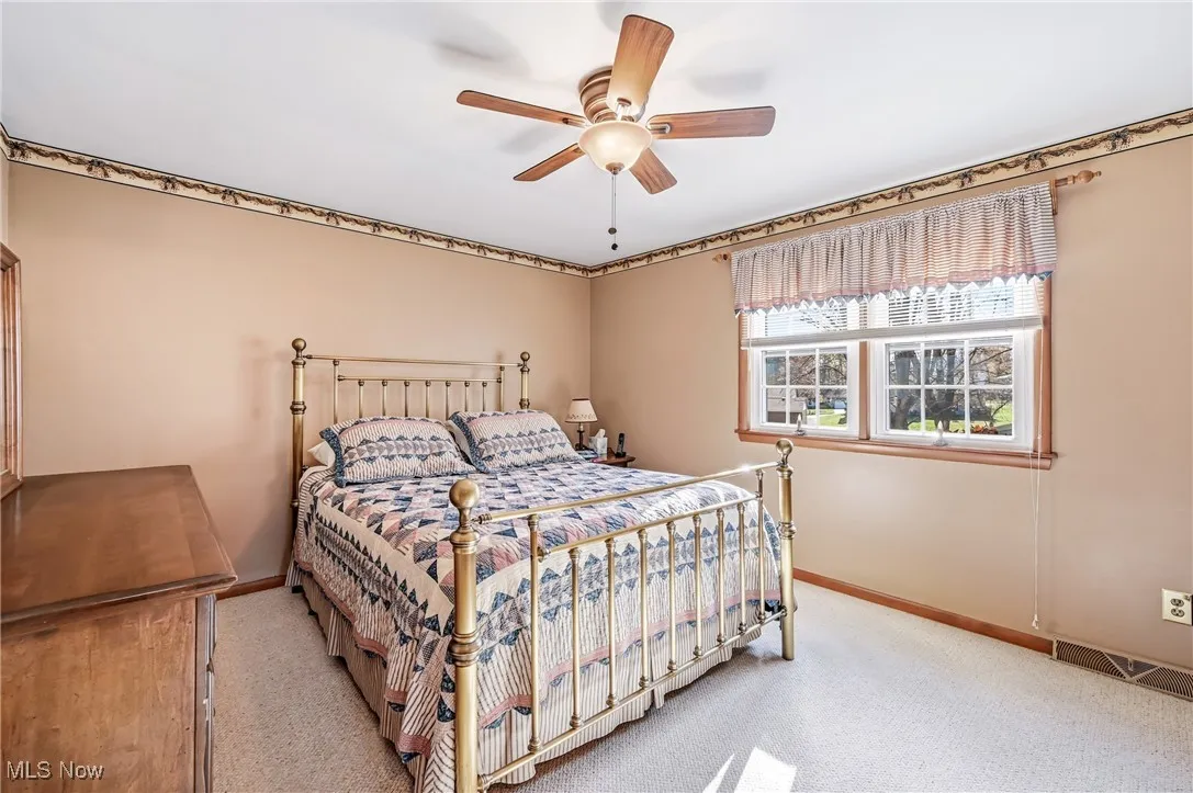 Primary Bedroom with walk in closet, fan and newer vinyl windows