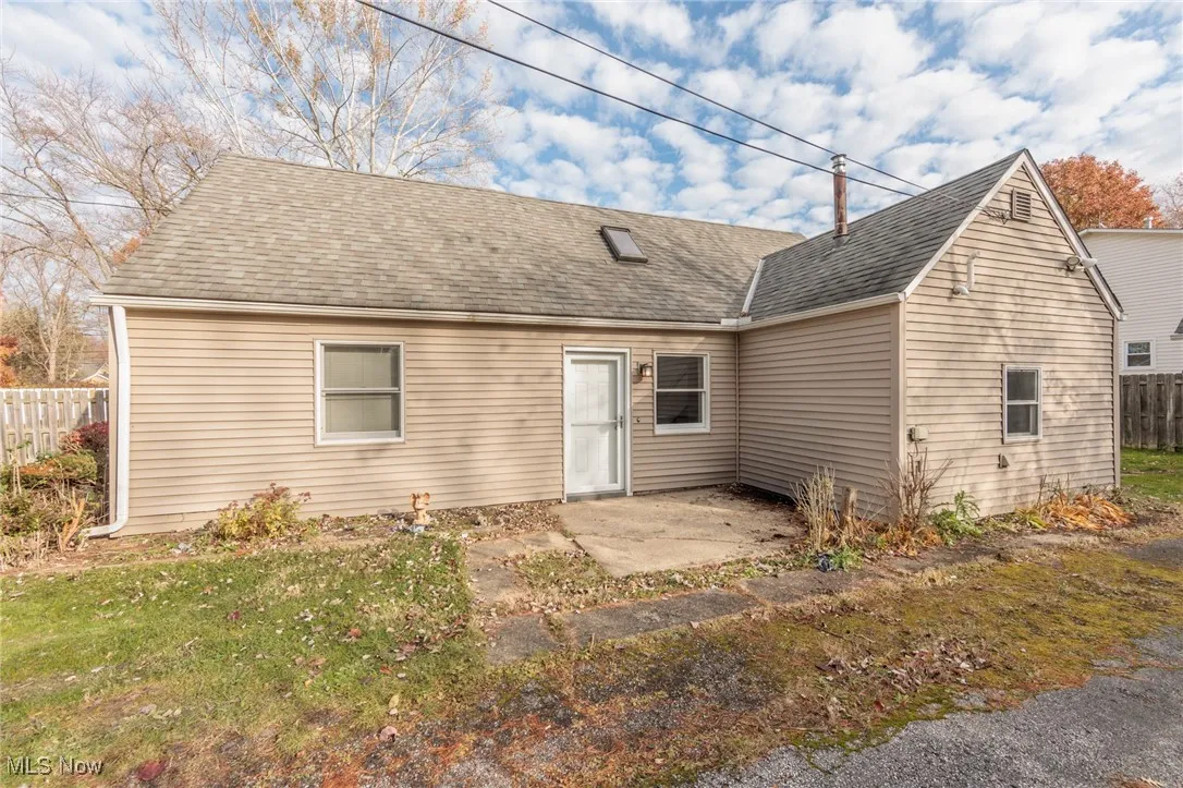 View of front facade featuring roof with shingles and a patio