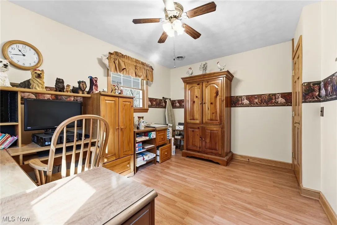 Bedroom used as office area featuring light wood-type flooring and ceiling fan