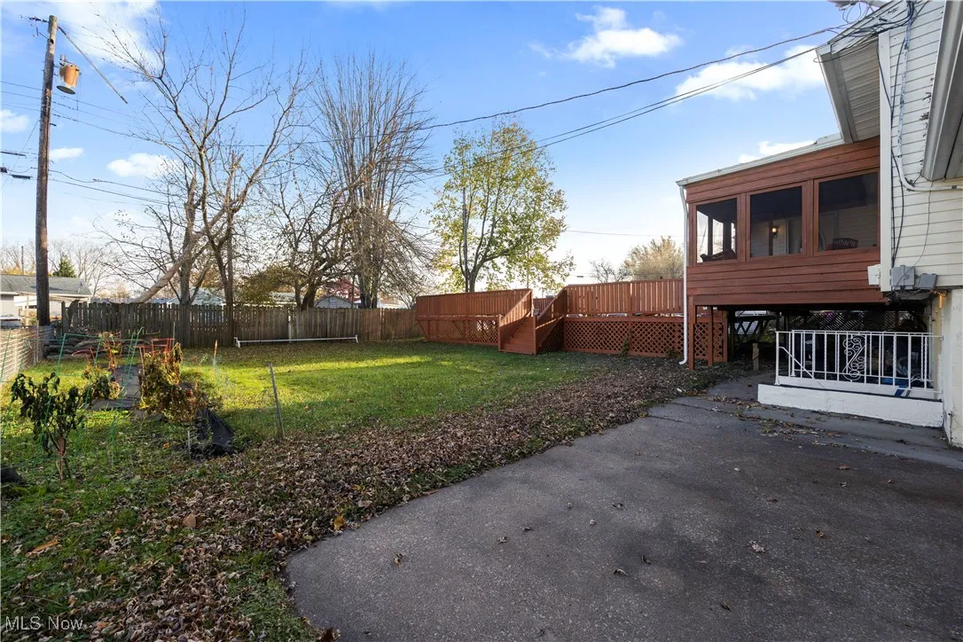 Fenced backyard with a sunroom, a patio area, and a deck