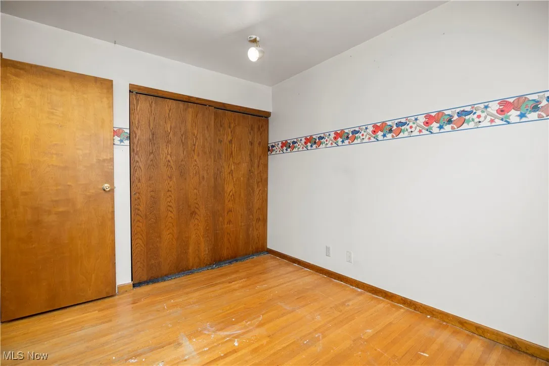 Unfurnished bedroom with light wood-type flooring and a closet