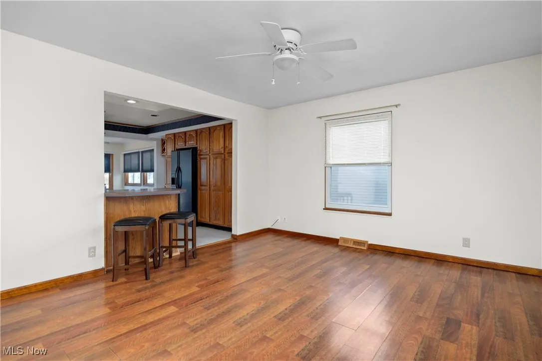 Kitchen featuring brown cabinetry, a kitchen bar, plenty of natural light, and light wood-style floors