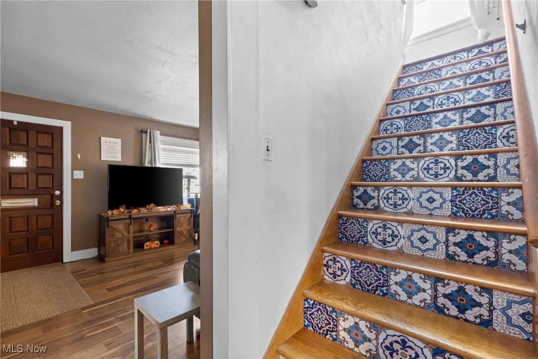 Stairs with wood finished floors and baseboards