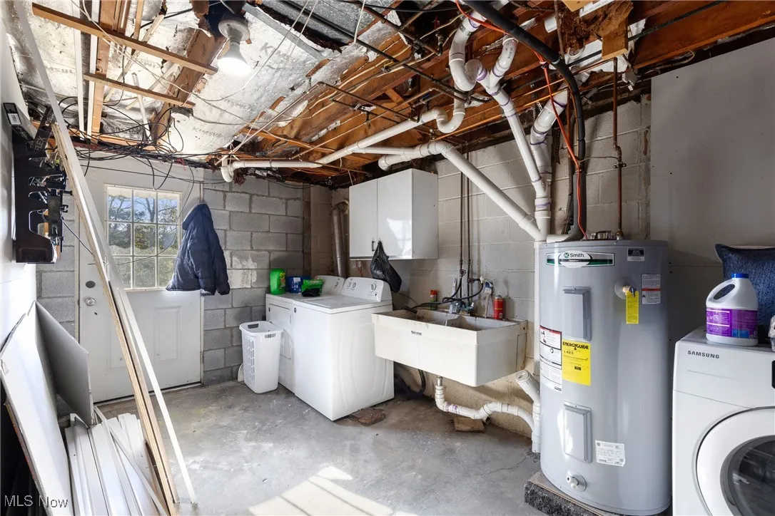 Basement featuring water heater and washing machine and dryer