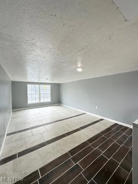 Bonus room with a textured ceiling