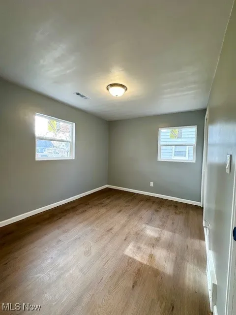 Spare room featuring light wood-style floors and baseboards