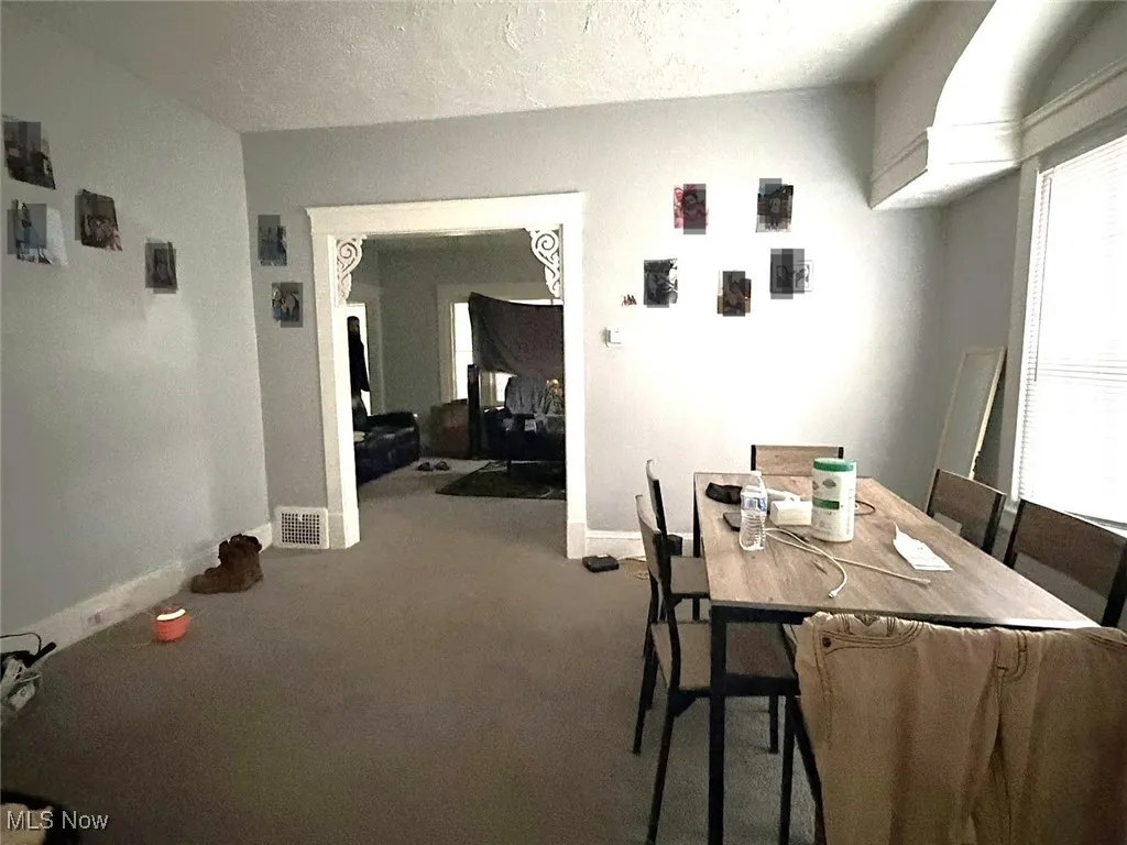 Dining area with a textured ceiling and carpet floors