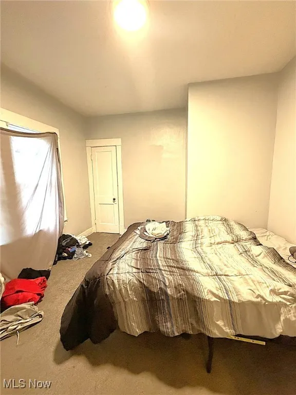 Carpeted bedroom featuring baseboards