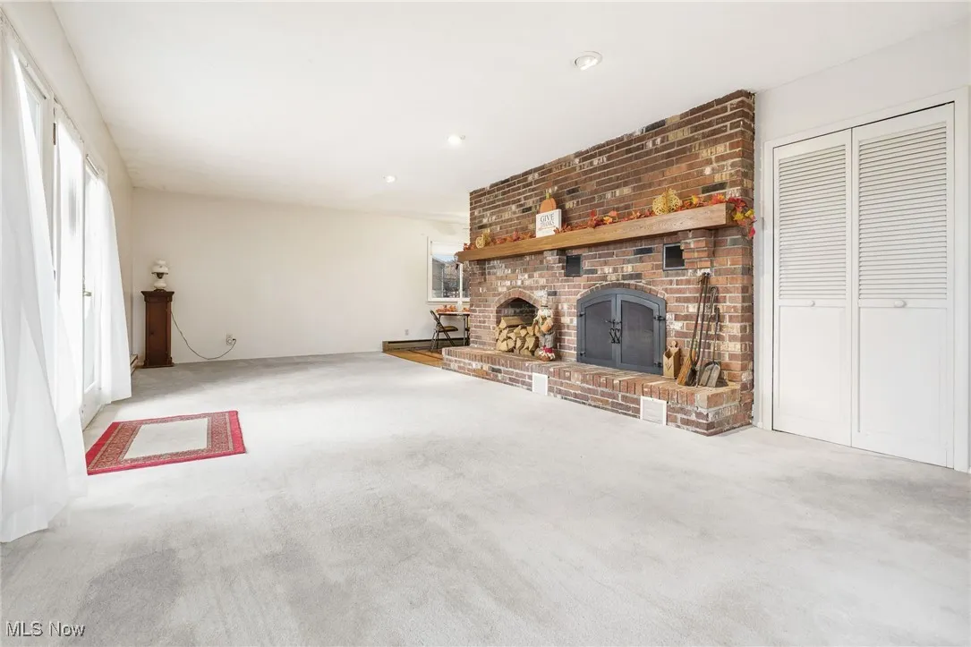 Living room featuring a brick fireplace, carpet, and recessed lighting