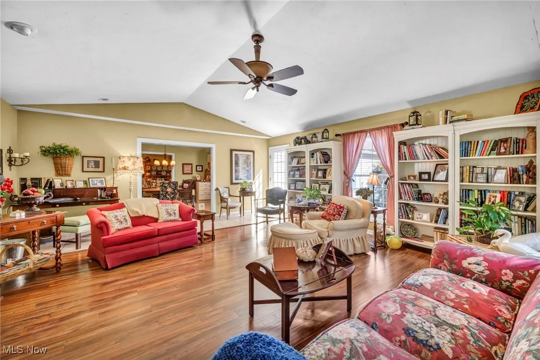 Living room featuring vaulted ceiling, wood finished floors, and a ceiling fan