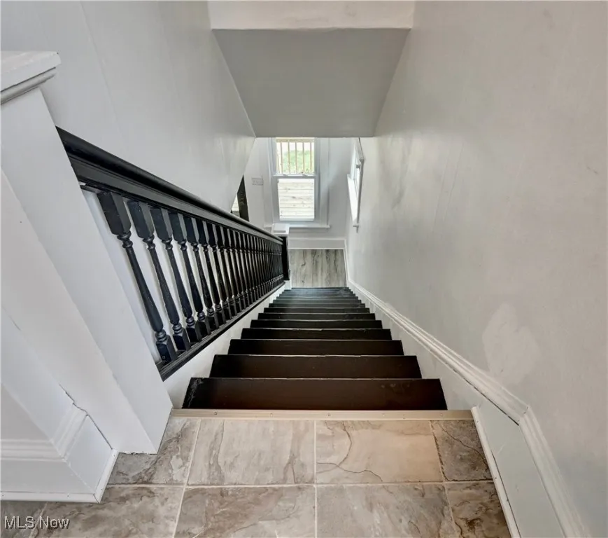 Stairs featuring wood finished floors