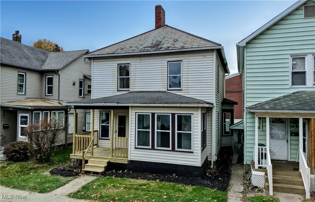 View of front of house featuring a chimney, a high end roof, and a front yard