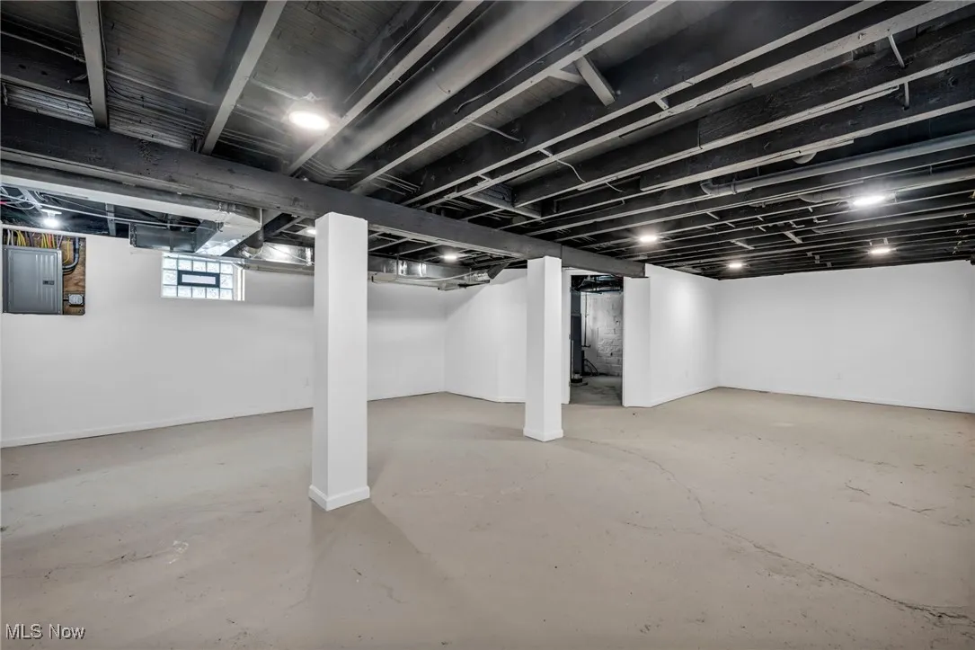 Below grade area with electric panel and baseboards