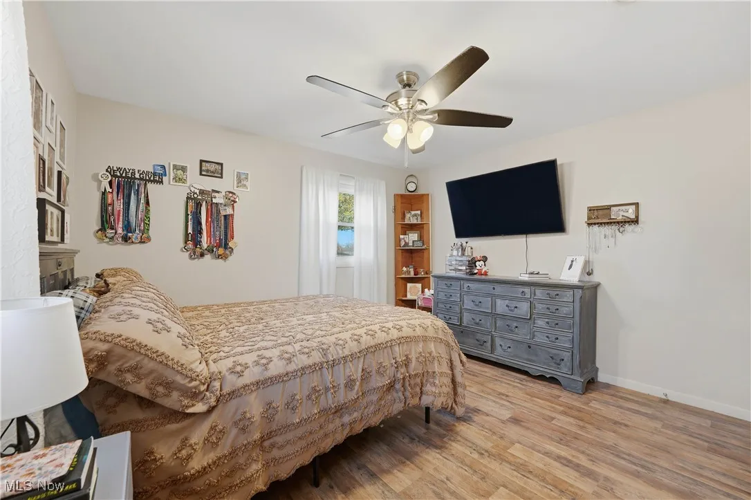Bedroom with light wood-style floors and a ceiling fan
