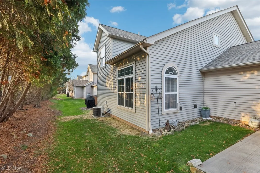 View of property exterior featuring a yard and roof with shingles