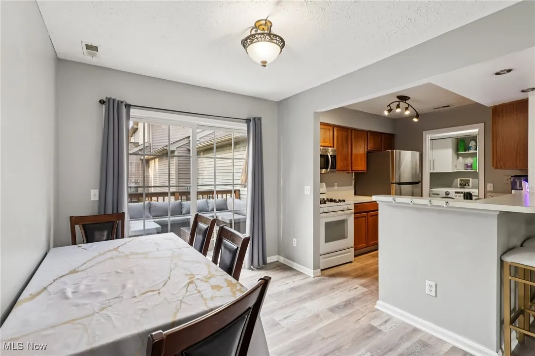 Dining room with light wood-style floors and a textured ceiling