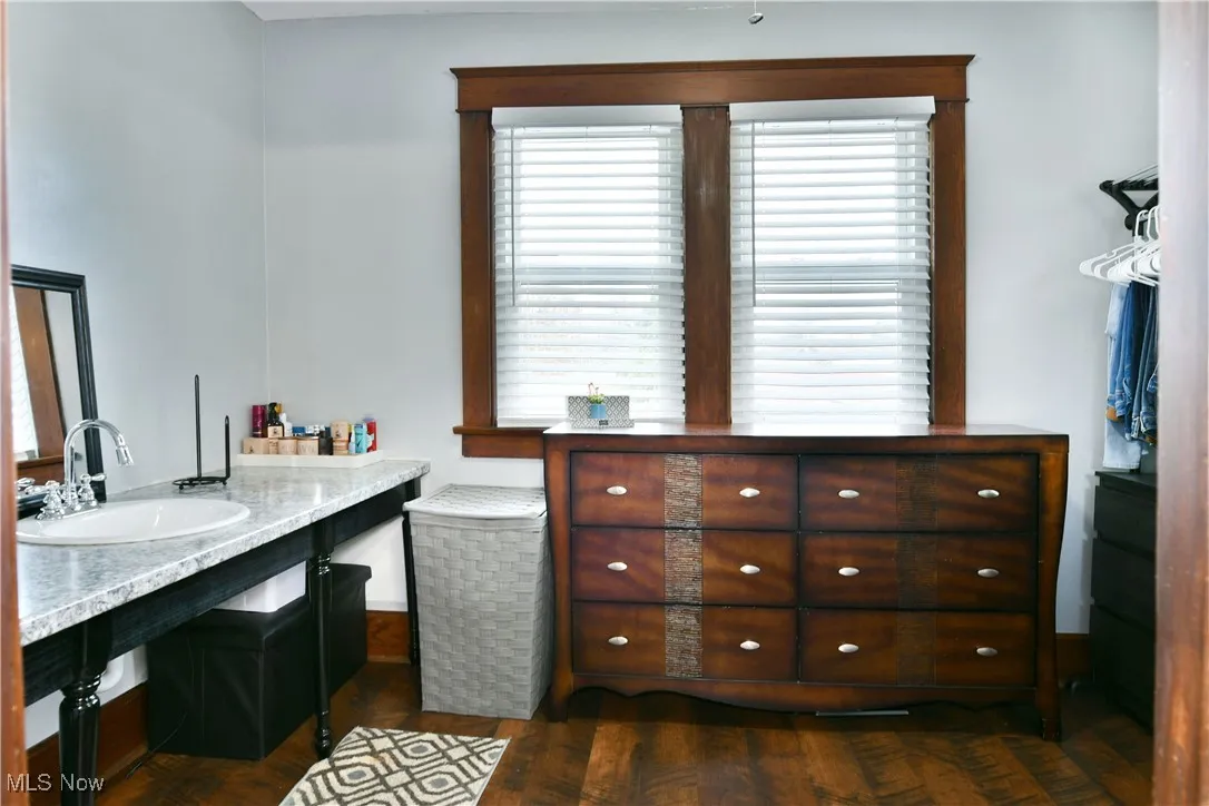 Full bathroom with dark wood-style floors and vanity